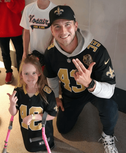 Before kickoff at the Superdome,QB Tyler Shough moves all of New Orleans — not with a throw, but with a white wristband bearing the words “FOR THEM 💙,” a tribute to underprivileged children
