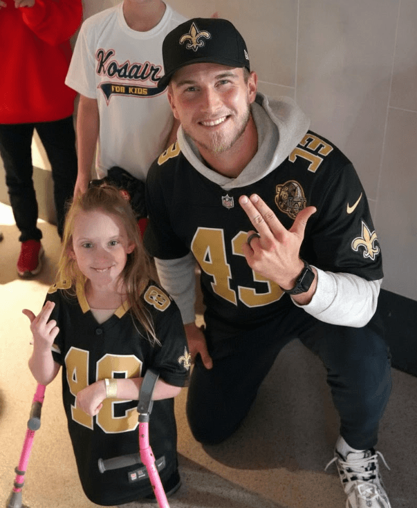 Before kickoff at the Superdome,QB Tyler Shough moves all of New Orleans — not with a throw, but with a white wristband bearing the words “FOR THEM 💙,” a tribute to underprivileged children